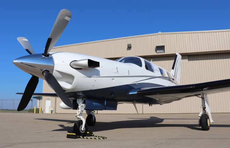 Turboprop aircraft parked in front of a hangar